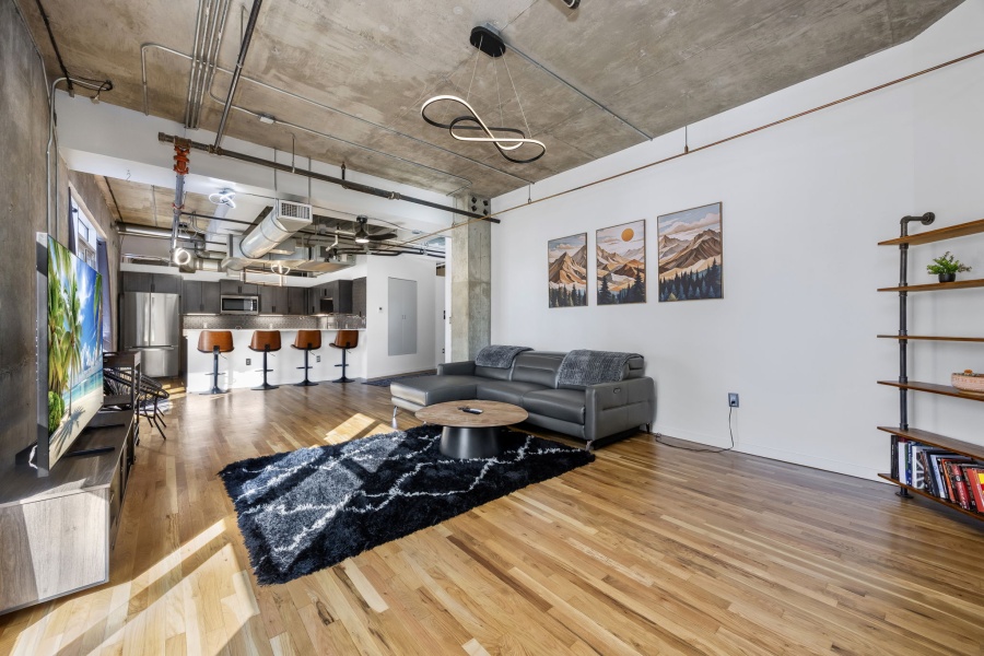 This fully furnished 1 bedroom, 1.5 bathroom condo is located in the sought-after Arapahoe SkyLofts, right in the heart of Denver. Offering 1,124 square feet of thoughtfully designed living space, this home blends modern loft-style character with comfort and convenience.
 
The condo features hardwood floors, concrete walls, and exposed ductwork, creating a clean, contemporary industrial aesthetic. The open living area flows seamlessly into the dining space, which includes seating for four, plus two bar stools at the kitchen counter, making it ideal for entertaining or casual meals.
 
The spacious primary bedroom is furnished with a king bed and provides a quiet retreat. The primary bathroom includes a tub/shower combination, while a convenient half-bath powder room is located off the main living area—perfect for guests. An in-unit washer and dryer adds everyday convenience.
 
Step out onto the private balcony and enjoy views of downtown Denver, a perfect spot for morning coffee or evening relaxation.
 
Parking is a rare downtown luxury, and this unit includes two parking spaces in the attached garage—one suitable for a compact vehicle and the other for a full-size car.
 
Built in 1983, Arapahoe SkyLofts is ideally situated near Union Station and Coors Field, with easy access to downtown office buildings, public transportation, and major roadways. The neighborhood offers an abundance of restaurants, coffee shops, and retail options, all within close proximity.
 
This fully furnished condo provides an exceptional opportunity to enjoy urban living with space, style, and convenience in one of Denver’s most vibrant locations.